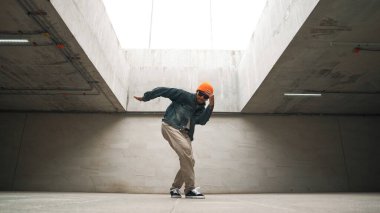 Modaya uygun mutlu hipster break dans ya da serbest dans yapıyor. Profesyonel break dansçı B-boy dansı yaparken şık kıyafetler giyiyor. Modern yaşam tarzı. Açık hava sporu 2024. Yumuşak bir şekilde..