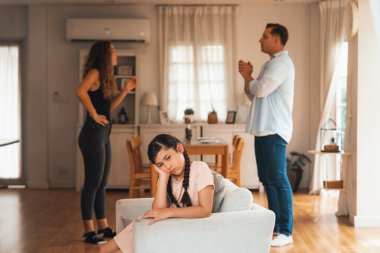 Sinirli ve mutsuz genç bir kız oturma odasında ebeveyninin tartışması yüzünden gerginliğin ortasında kanepede oturuyor. Sağlıksız ev hayatı ve travmatik çocukluk depresyona dönüşür.