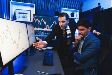 İki yatırımcı ilginç piyasa hisselerini tartışıyor ve monitöre doğrultuyor. Neon ışıklı işyeri seçmeyi planlama amaçlı dinamik ekonomik yatırım teknolojisinin eğilimi. Satılabilir.