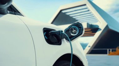 EV şarj istasyonundan şarj olan elektrikli araba akıllı dijital batarya durum hologramını gösteriyor. Alternatif ve sürdürülebilir enerji kullanan şarj edilebilir EV arabaların teknolojik gelişimi. İnceleyin