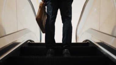 Yürüyen merdivenlerde duran zeki profesyonel iş adamının bacağı. Yetenekli proje yöneticisi terfi alıyor, yeteneğini arttırıyor, yükseltiyor, yeni bir pozisyon alıyor. Merkez. Bacağa odaklan. Sevinçli..