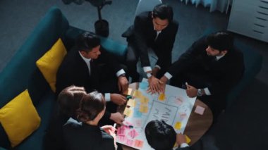 Profesyonel iş adamlarının el ele tutuşup başarılı bir projeyi kutlamak için el çırpışları ve beyin fırtınası fikrini zihin haritalamada kullanışları. Sevgi ve birliği temsil ediyordu. Müdürlük.