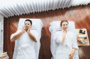 Kaplıca salonunun sakin, modern gündüz atmosferi, birkaç müşteri yüz maskesi takarak kendini yenilemeye çalışıyor. Yüz bakımı ve güzellik kozmetolojisi prosedürü. Sessiz.