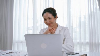 Çalışma masasında internet içeriği için dizüstü bilgisayar kullanan genç bir iş kadını ya da evden çalışan bir sekreter. Canlılık