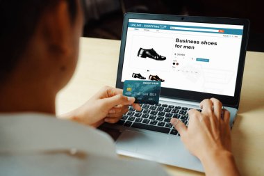 Genç adam, laptop bilgisayar başvurusu ya da web sitesinde online alışveriş yapmak için kredi kartı kullanıyor. E-ticaret ve online alışveriş konsepti. uds