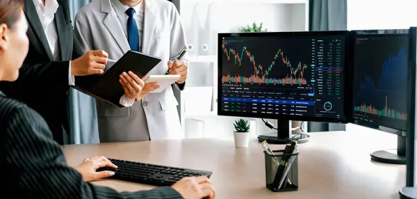 プロのビジネスマンは 金融投資について議論します 女性ブローカーは成長グラフを提示し 協力的な投資家はノートパソコンの情報と財務データを比較します バージョニング — ストック写真