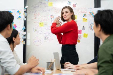Profesyonel çekici kadın lider, modern iş toplantı odasında beyin fırtınası zihin haritalama istatistikleri ve renkli yapışkan notlar kullanarak yaratıcı pazarlama planını sunuyor. Tertemiz..