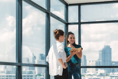 Genç, güzel, profesyonel mimar mühendis takımının portresi ev tasarımı hakkında konuşuyor. Yetenekli iş kadını beyin fırtınası yapıyor ve gökdelenle çevrili pazarlama fikirlerini paylaşıyor. İzleme.