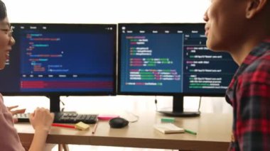 Yavaş çekim arkası yazılım geliştirici mühendisi bilgisayar programlama için birlikte çalışarak hata ayıklama kodunu çözüyor, ofiste monitörde karmaşık algoritmaları çözüyor. Filizlenen