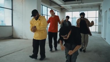 Çok kültürlü dansçılar sokak dansı yapıyor ve hip-hop müziğine geçiyorlar. Profesyonel hipster grubu gökyüzü kavgacı görünümlü bir binada serbest stil müzik eşliğinde dans ediyor. Açık hava sporu 2024 hiphop..