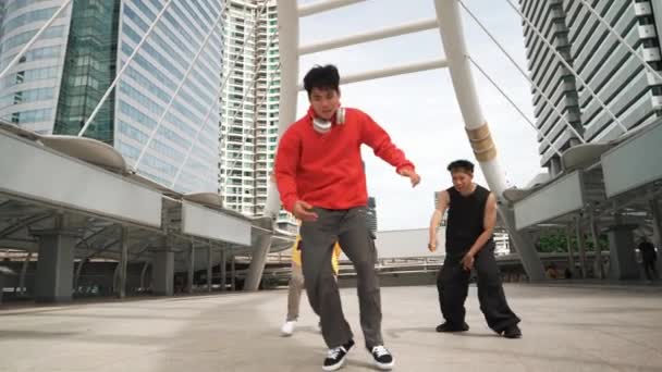 熟练的嬉皮士在城市表演脚步声时一起跳舞 专业的霹雳舞蹈演员一边欣赏音乐一边看着镜头 低角度相机 现代生活方式 2024年户外运动 神气活现 — 图库视频影像