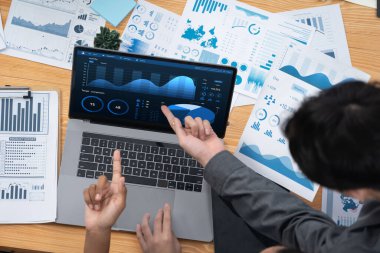 Çok ırklı analist ekibi toplantı masasındaki finansal verileri analiz etmek için BI Fintech yazılımı kullanıyor. Finansal konsol veri ekranında pazarlama göstergesi için analiz edilmiş grafikle birlikte. Uyum