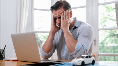 Stresli ve hayal kırıklığına uğramış araba tasarım mühendisi, dizüstü bilgisayarla çözüm bulmaya çalışırken, araç tasarımında bir kusur keşfettikten sonra kafasını eline verdi.