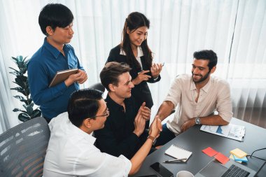 Çeşitli ofis çalışanları stratejik iş pazarlama toplantısı üzerine anlaşma yaptıktan sonra el sıkışıyor. Takım çalışması ve olumlu tutum verimli ve destekleyici bir iş yeri yaratır. Tedbirli