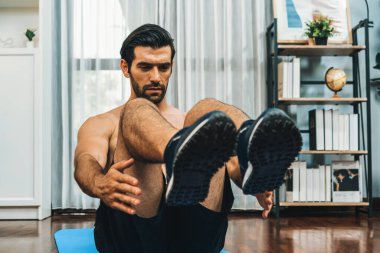 Atletik ve sporcu adam, evde vücut egzersizi yaparken spor ve spor yaşam tarzına uyum sağlamak için spor minderinde çatırdıyor. Gaiety ev egzersizi antrenman konsepti.