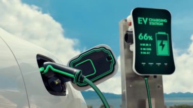 Fütürist akıllı EV şarj istasyonunun temiz enerji şarj pilini kullanarak doğal arka planda çevre dostu elektrikli araba. Alternatif enerji sürdürülebilirliği ve EV kullanımı. PeruseE