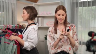 İki kadın nüfuzlu kişi canlı yayın yapan video klip eleştirisi kıyafetlerini sosyal medyada ya da blogda yayınlıyor. Stüdyo ışıklandırmalı mutlu genç kız çevrimiçi pazarlama oturumu yayını için..