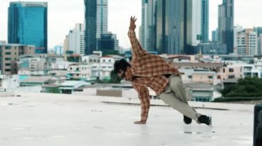İspanyol break dansçı B-boy dansçısının ayak seslerini şehir manzaralı ya da gökdelenli çatıda pratik yapıyor. Genç modern dans grubu hip hop hareketi yapıyor. Tarz, moda, aksiyon. Açık hava sporu 2024 hiphop..