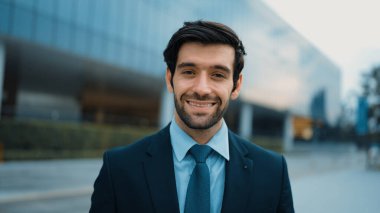 Binada dikilirken kameraya bakan gülümseyen iş adamının portresi. İş elbisesi giyerken kameraya gülümseyen başarılı adamın yakın çekimi. Mutlu yönetici kameraya bak. Sevinçli..