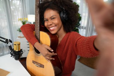 Hayranları için selfie çeken genç Afrikalı Amerikalı müzisyenin sunucu kanalı, özel bir stüdyoda akıllı telefondan yayın yapıyor. Kulaklık dekorasyonu ve mikrofon kaydı. Tatlandırıcı.