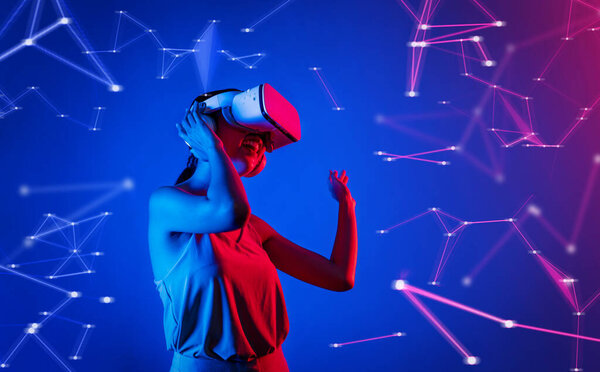 Female standing wearing white VR headset and tank top connecting metaverse, future cyberspace community technology, enjoy dancing in cyberpunk neon light gesticulate hand and body. Hallucination.