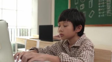 BTMM teknoloji sınıfında kodlama mühendisliğini öğrenirken Asyalı çocuk dizüstü bilgisayarı üzerinde çalışıyor. Yapay zeka üretmek için yazılım sistemini araştıran çekici ve zeki öğrenciler. Pedagoji.