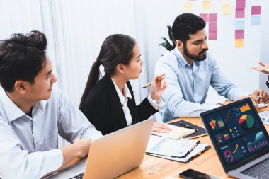 Çok ırklı analist ekibi toplantı masasındaki finansal verileri analiz etmek için BI Fintech yazılımı kullanıyor. Finansal konsol veri ekranında pazarlama göstergesi için analiz edilmiş grafikle birlikte. Uyum