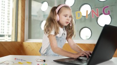 Dizüstü bilgisayarda çalışan ya da online sınıfta okuyan genç bir öğrenci. Ev ödevi yaparken ya da müzik dinlerken bilgisayarda yazan beyaz bir kız. Kulaklık takan küçük bir çocuk. Yaratıcı öğrenme. Etkinlik.