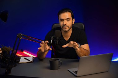 Yayıncı, fanclub dinleyicisiyle mikrofon kullanarak konuşuyor. Mor neon ışıklı modern stüdyoda yaratıcı olumlu düşünce konseptiyle canlı yayında finansal sorunları tartışıyor. Tahmin et..