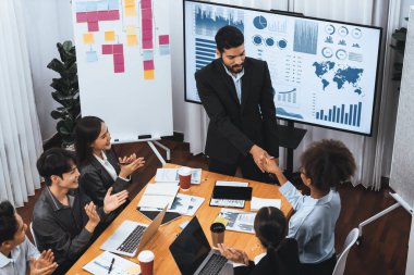 Çeşitli iş arkadaşları bunu şirket işyerinde el sıkışma ve takım çalışmasıyla kutluyor. Başarılı bir toplantıdan sonra el sıkışmayla ya da veri analizi üzerine iş sunumuyla birleşen mutlu iş adamları. Uyum