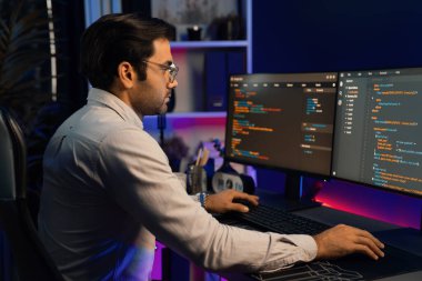 İki pc ekranda veri yazılım geliştirme analizi yapan akıllı bilişim geliştiricisi, neon ışıklı siber ofiste güncellenmiş uygulama programı güncellenmiş online web sayfası sistemi yaratıyor. Tahmin et..