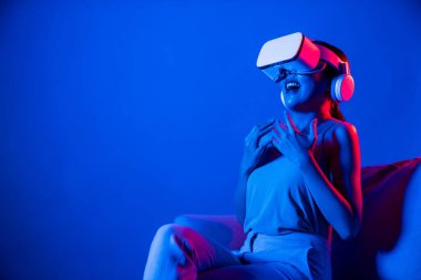 Kanepede oturan zeki kadın, neon ışıklarla çevrili VR kulaklık takıyor metazele bağlanıyor, gelecekçi siber uzay topluluğu teknolojisi. Zarif kadın heyecanlı ve duygusal olarak film izliyor. Halüsinasyon.