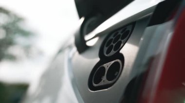 EV şarj prizi kapağı elektrikli arabaya bağlanıyor, EV araba aküsünü temiz çevre için sıfır CO2 emisyonu ile alternatif ve sürdürülebilir enerjiyle şarj ediyor. Titiz
