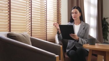 Mutlu ve gülümseyen kadın psikolog psikiyatri ofisinde ya da terapi odasında pano tutuyor. Arkadaş canlısı ve profesyonel ruh sağlığı danışmanı ya da terapisti. Blithe