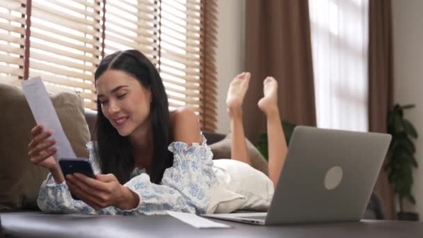 Νεαρή Γυναίκα Ξαπλωμένη Στον Καναπέ Χρησιμοποιώντας Φορητό Υπολογιστή Πιστωτική Κάρτα — Αρχείο Βίντεο