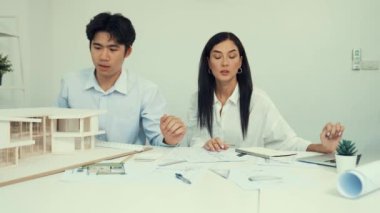 Genç, zeki, yakışıklı mühendis ev modelini ölçerken genç, beyaz, iç tasarımcı önemli noktayı işaret ediyor. Birlikte çalışıyoruz, takım olarak çalışıyoruz. Yaratıcı tasarım konsepti. Tertemiz..