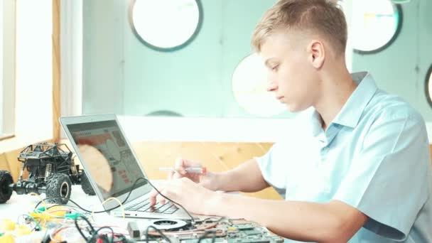 Vista Lateral Estudante Olhando Para Tela Laptop Fixando Placa Eletrônica — Vídeo de Stock