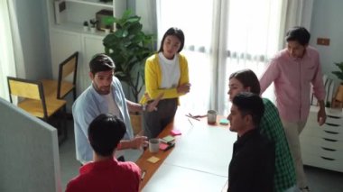 Bir grup insan toplantıda pazarlama planını tartışıyor. Erkek lider karatahta ve mevcut planda dururken, akıllı yöneticilerin konuşup yaratıcı fikirleri paylaştıklarının en üst görüşü. Cemaat.