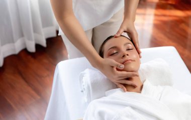 Kafkasyalı kadın stres önleyici kafa masajından ve lüks tatil beldesi ya da otel spa salonundaki modern ışık ortamında yüz güzelliği eğlencelerini şımartmaktan hoşlanıyor. Sessiz.