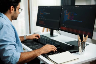 Akıllı IT geliştiricisi yazılım geliştirme kodlaması ile modern ofisteki iki bilgisayar kodlu bilgisayar sistemi üzerinde uygulama programı güncelleme çevrimiçi web sitesi yaratıyor. Tahmin et..