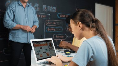 Öğretmenler kodlama sistemini öğretirken, farklı akademik öğrenciler STEM teknoloji sınıfında ana tahtayı dizüstü bilgisayar programlama programlama komut veya mühendislik koduyla düzeltiyorlar. Öğretim.