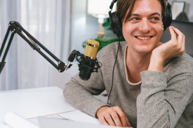 Sunucu kanalı, gülümseyen akıllı yayıncı kaydı, senaryosu ve akıllı telefonuyla sosyal medyada sohbet programı, kulaklık takarak modern ev stüdyosundaki video flamalarını kaydediyor. Bireysel.