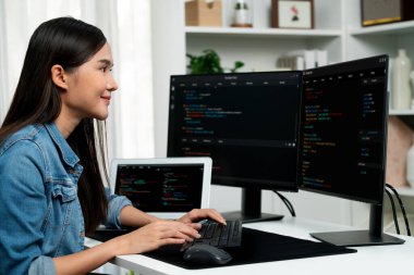 İnternet sitesi uygulamasının kodlama verileriyle birlikte online bilgi yazarak kot gömlek giyen genç Asyalı geliştirici. Güvenlik analizi ile çevrili iki ekran. Taktik.