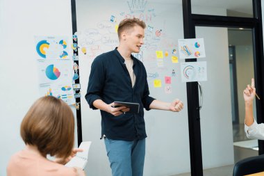 Profesyonel erkek lider projeye zihin haritası, renkli yapışkan notlar ve iş istatistiksel grafiği ile yatırımcı toplantısını dinlerken kendinden emin bir şekilde başlayarak başlıyor. Tertemiz..