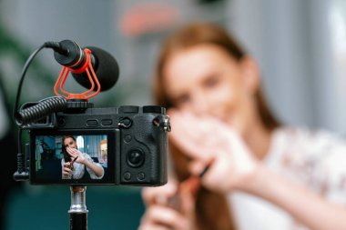 Kadın Etkilenen Vlog video görüntülerini sosyal medya ya da blog 'da en üst düzeyde yayınlıyor. Kozmetik stüdyosu ışıklandırmalı mutlu genç kız çevrimiçi pazarlama oturumu yayını için..