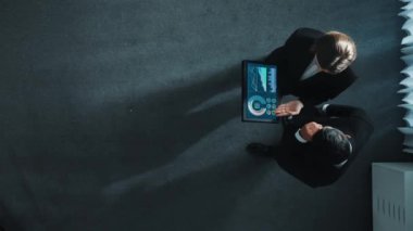 Yetenekli iş adamının yukarıdan görünüşü bir ekibe katıldı ve yönetici müdürle tokalaştı. Pazarlama ekibinin tabletteki yatırım verilerini analiz etmek için birlikte çalışması zaman aşımı. Müdürlük.