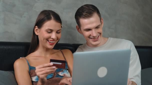 若いカップルは クレジットカードで支払うためにラップトップ上のオンライン決済アプリとデジタルウォレットを使用してホームベッドルームに座っています モバイルインターネットを介して商業ショッピングとモダンな購入 アディット — ストック動画