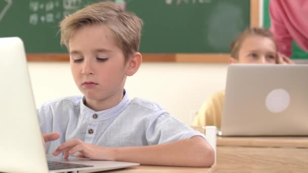 Biały Chłopiec Pracujący Laptopie Podczas Gdy Różnorodne Dzieci Programują Oprogramowanie — Wideo stockowe