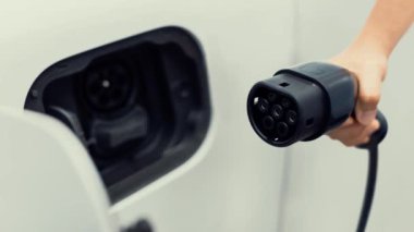 Kameranın önüne odaklanmış EV şarj cihazı fütüristik akıllı dijital EV batarya durum hologramını gösteriyor. EV araba şarjı sürdürülebilir güç için alternatif enerji kullanıyor. İnceleyin