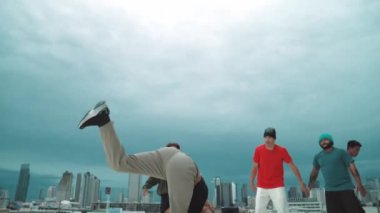 İspanyol hipster dansları şehrin mavi gökyüzü manzaralı çok kültürlü arkadaşlarıyla çevrili. Çatıda bir grup sokak dansçısı sahne alıyor. Aktif, eğlenceli, mutlu atmosfer. Açık hava sporu 2024 hiphop..